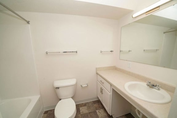 a bathroom with a sink toilet and a mirror  at Arbor Lakes Apartments, Elkhart, IN