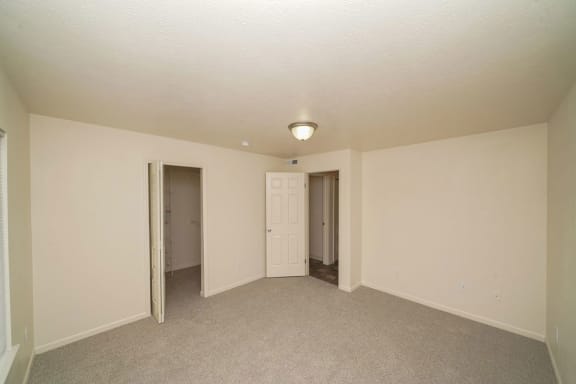 an empty living room with a door to a hallway