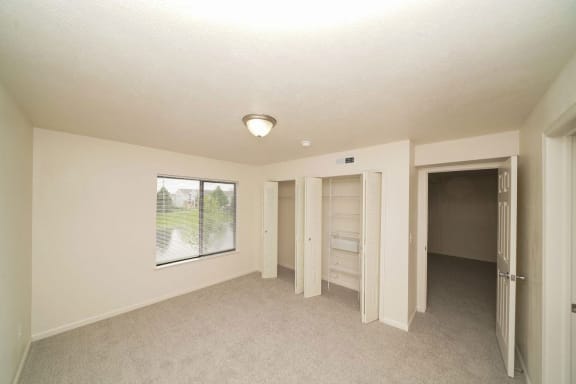 an empty living room with a window and a closet  at Arbor Lakes Apartments, Indiana