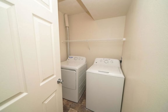 a washer and dryer in a room with a door  at Arbor Lakes Apartments, Elkhart, IN, 46516