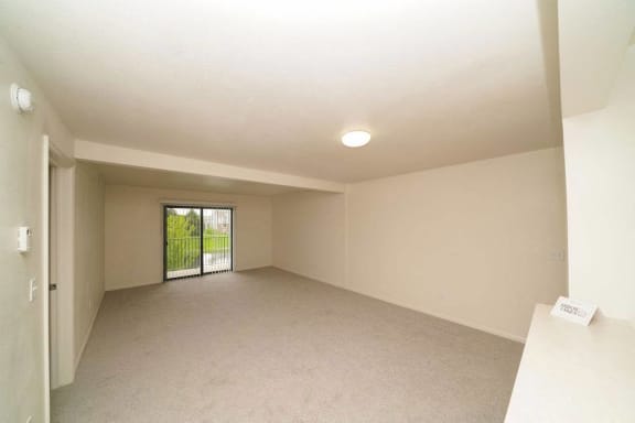 an empty living room with a sliding glass door  at Arbor Lakes Apartments, Elkhart, IN, 46516