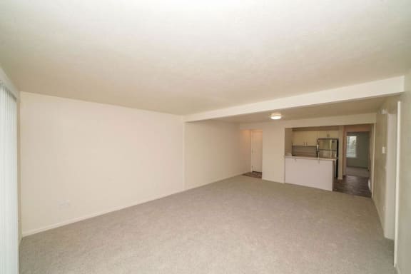an empty living room with a kitchen in the background  at Arbor Lakes Apartments, Elkhart, IN, 46516