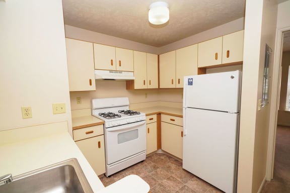a kitchen with white appliances and white cabinets at Autumn Lakes Apartments and Townhomes, Mishawaka, Indiana