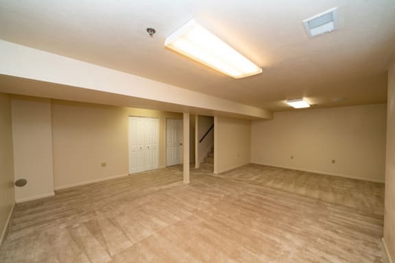 an empty living room with a door to a staircase at Autumn Lakes Apartments and Townhomes, Mishawaka, IN