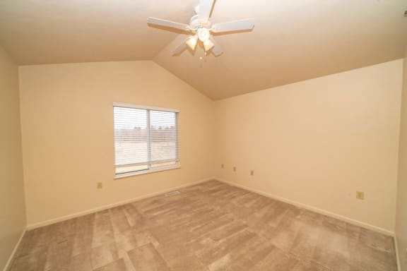 an empty bedroom with a ceiling fan and a window at Autumn Lakes Apartments and Townhomes, Mishawaka, IN