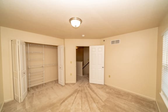 an empty bedroom with a closet and a door to a bathroom at Autumn Lakes Apartments and Townhomes, Mishawaka, 46544