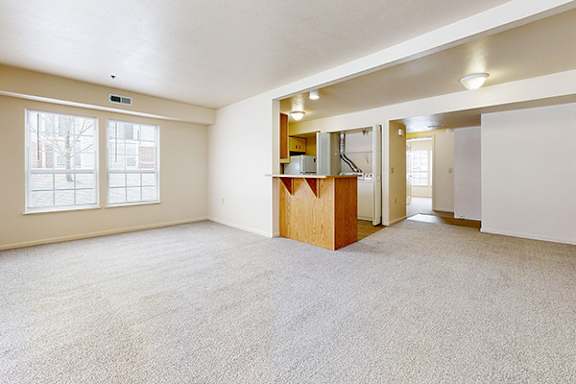 A spacious end living room with a carpeted floor at Autumn Lakes Apartments and Townhomes in Mishawaka, IN