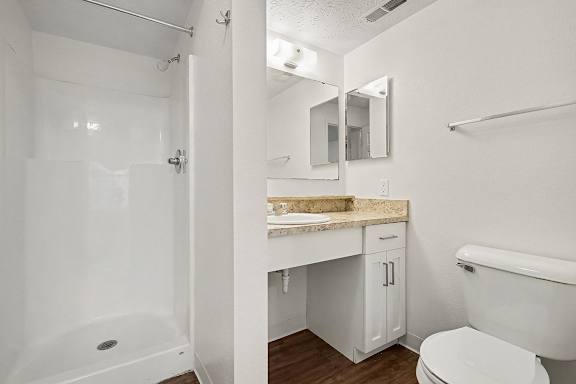 A white bathroom with a tub, toilet, and sink.