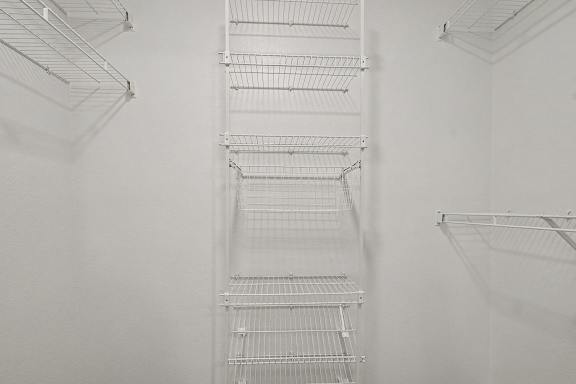 Empty white shelves in a refrigerator.