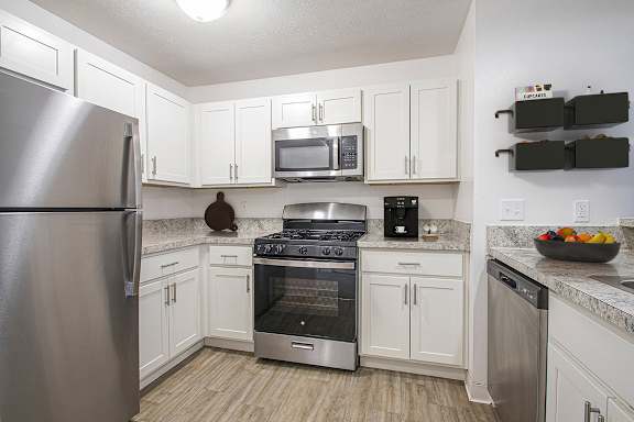 A kitchen with white cabinets and a stainless steel appliances at Autumn Lakes Apartments and Townhomes in Mishawaka, IN
