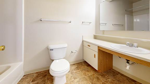A white toilet sits in a bathroom next to a sink.