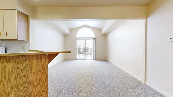 A room with a wooden counter and carpeted floor.