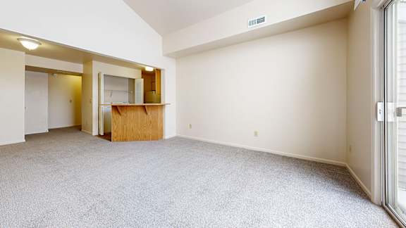 A room with a carpeted floor and a wooden door.