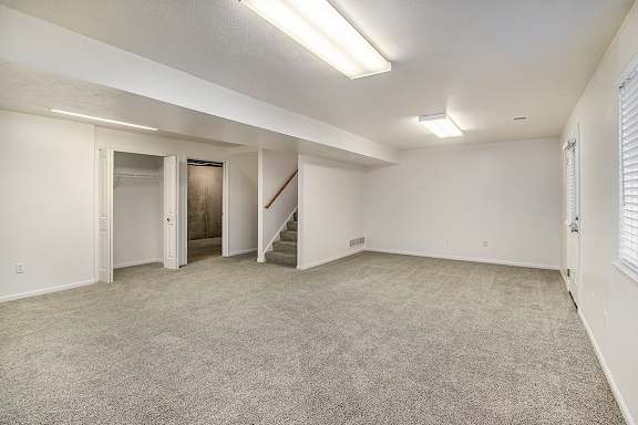 A basement rec room with a staircase and a window at Autumn Lakes Apartments and Townhomes, Mishawaka, 46544
