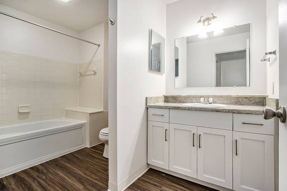 A white bathroom with a tub, toilet, and sink at Autumn Lakes Apartments and Townhomes, Mishawaka, 46544