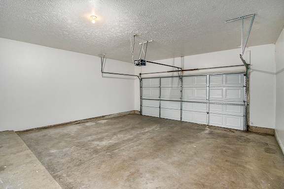 A 2+ car garage with a white wall and a white door at Autumn Lakes Apartments and Townhomes, Mishawaka, 46544