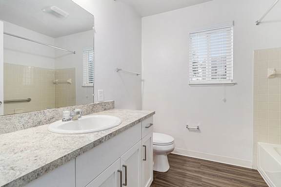 A white bathroom with a window, sink, toilet, and bathtub at Autumn Lakes Apartments and Townhomes, Mishawaka, 46544