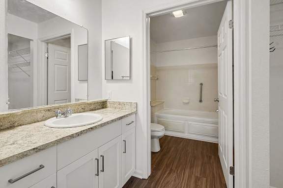 A white bathroom with a sink, toilet, and bathtub.