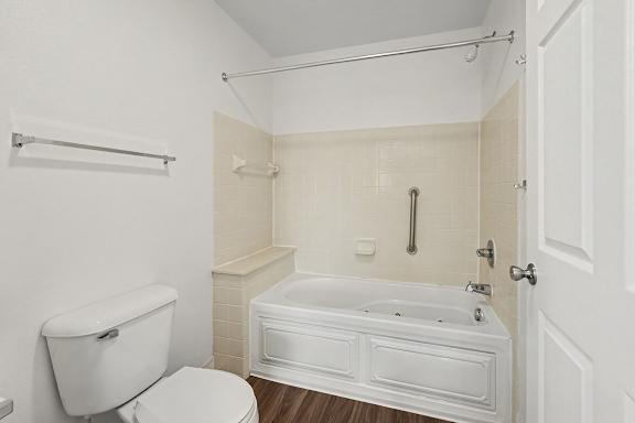 A white bathroom with a toilet, tub, and shower.