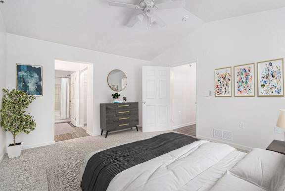 A bedroom with a ceiling fan, a walk-in closet, and an ensuite bathroom at Autumn Lakes Apartments and Townhomes, Mishawaka, 46544