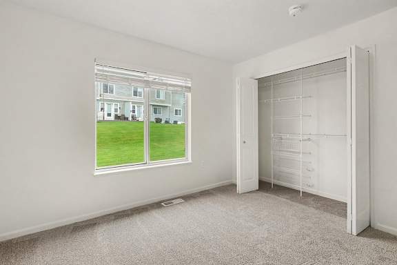 A room with a large window and a white door.