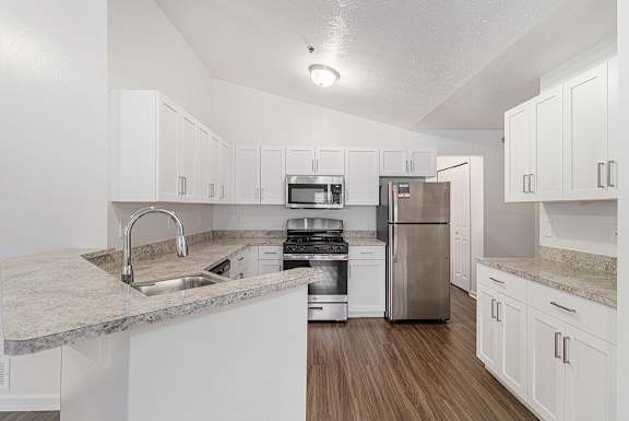 A kitchen with white shaker-style cabinets and hard-surface countertops at Autumn Lakes Apartments and Townhomes, Mishawaka, 46544
