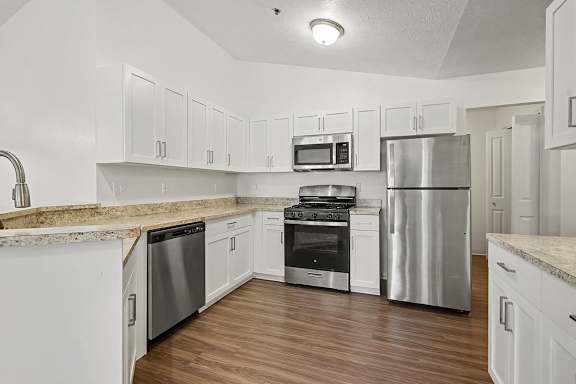 A kitchen with white cabinets and stainless steel appliances.