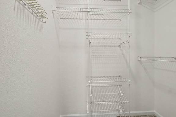 A white walk in closet with shelves and hangers at Autumn Lakes Apartments and Townhomes in Mishawaka, IN