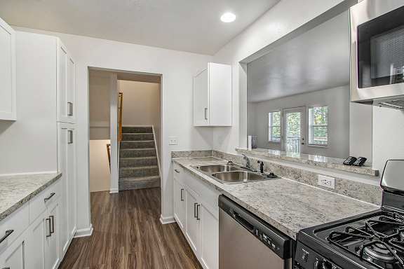 A kitchen with white cabinets and a stainless steel refrigerator