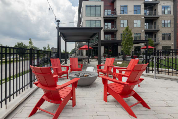 a group of red chairs sitting around a fire pit on a patio at Avant & Avant II, Carmel, IN, 46032