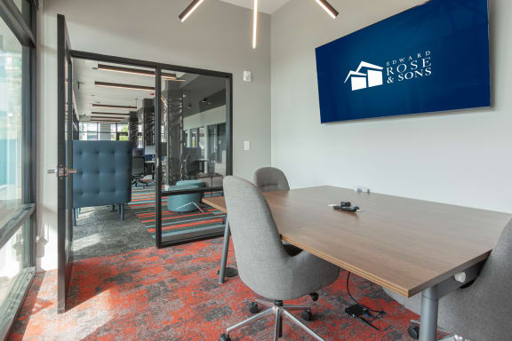 a conference room with a table and chairs and a TV in Carmel, IN
