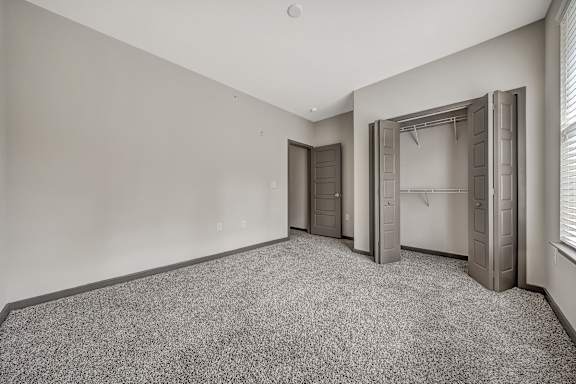 an empty room with a closet and a window at Avellan Springs Apartments, Morrisville