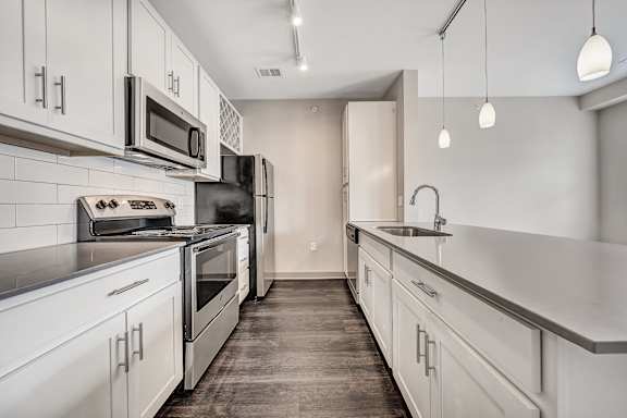 an empty kitchen with white cabinets and stainless steel appliances at Avellan Springs Apartments, Morrisville, NC
