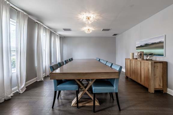 A dining room with a wooden table and blue chairs at Pheasant Run Apartments, Indiana, 47909