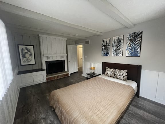 A bedroom with a large bed and a fireplace.