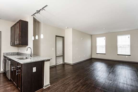 an empty living room and kitchen with wood flooring and a counter top at Bella Vista Apartments, Fishers, Indiana