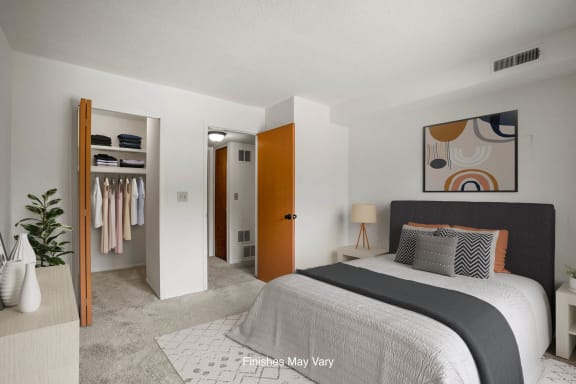 a bedroom with a bed and a closet at Beacon Hill and Great Oaks Apartments, Rockford
