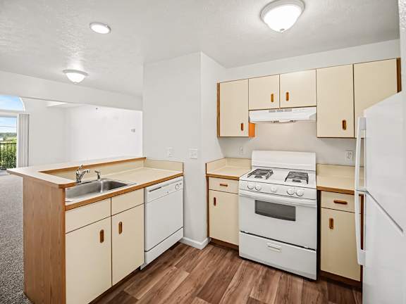 A kitchen with white appliances and wooden cabinets at Black Sand Apartments Homes, Lincoln, NE 68504