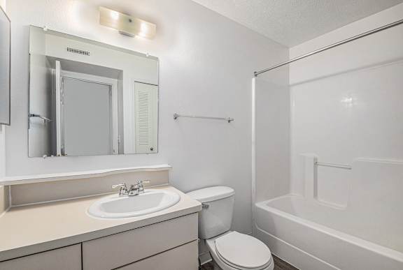 A white bathroom with a toilet, sink, and bathtub at Black Sand Apartment Homes, Lincoln, Nebraska