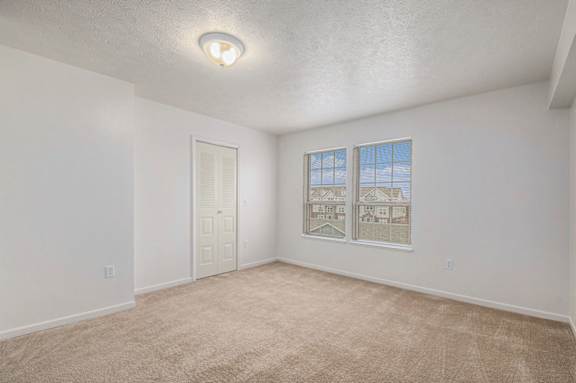 A bedroom with a carpeted floor and large windows at Black Sand Apartment Homes, Lincoln, Nebraska