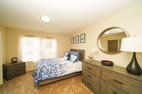a bedroom with a bed and a mirror at Brentwood Park Apartments, La Vista, Nebraska