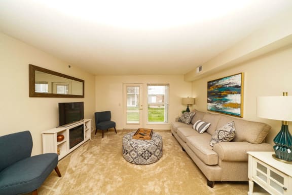 a living room with a couch and a television at Brentwood Park Apartments, La Vista, NE