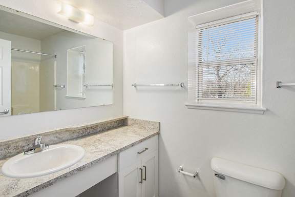 A bathroom with white cabinets and a window at Brentwood Park Apartments, La Vista, 68128s.
