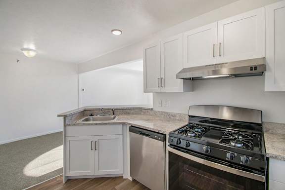 A kitchen with white cabinets and a stainless steel gas stove and dishwasher at Brentwood Park Apartments, La Vista, 68128