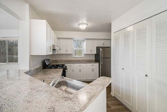 A kitchen with white cabinets and a window at Brentwood Park Apartments, La Vista, 68128