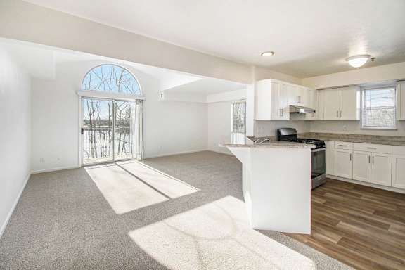 A sunny day in an enlarged living room with a cathedral ceiling and kitchen at Brentwood Park Apartments, La Vista, 68128