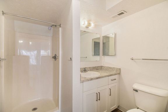 A bathroom with a shower, toilet, and sink at Brentwood Park Apartments in LaVista, NE