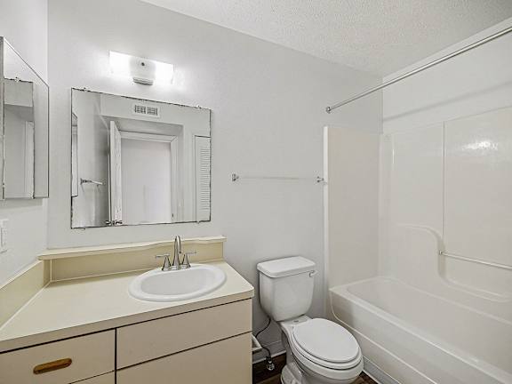 A white bathroom with a sink, toilet, and bathtub at Brentwood Park Apartments in LaVista, NE
