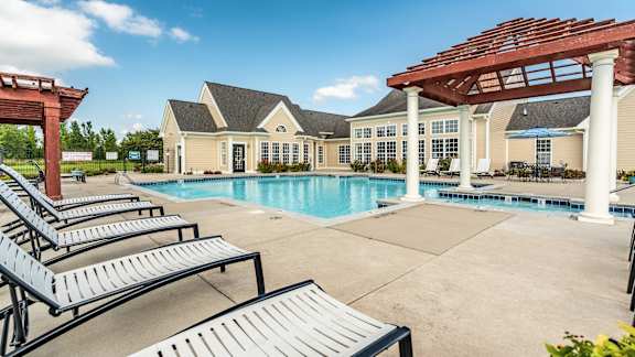 A pool area with sun loungers and a pavilion