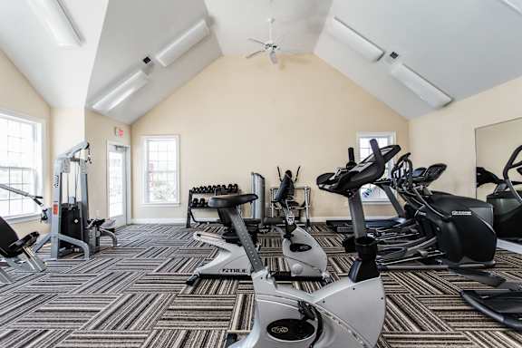 a gym with cardio machines and weights on the floor at Brickshire Apartments, Merrillville, Indiana